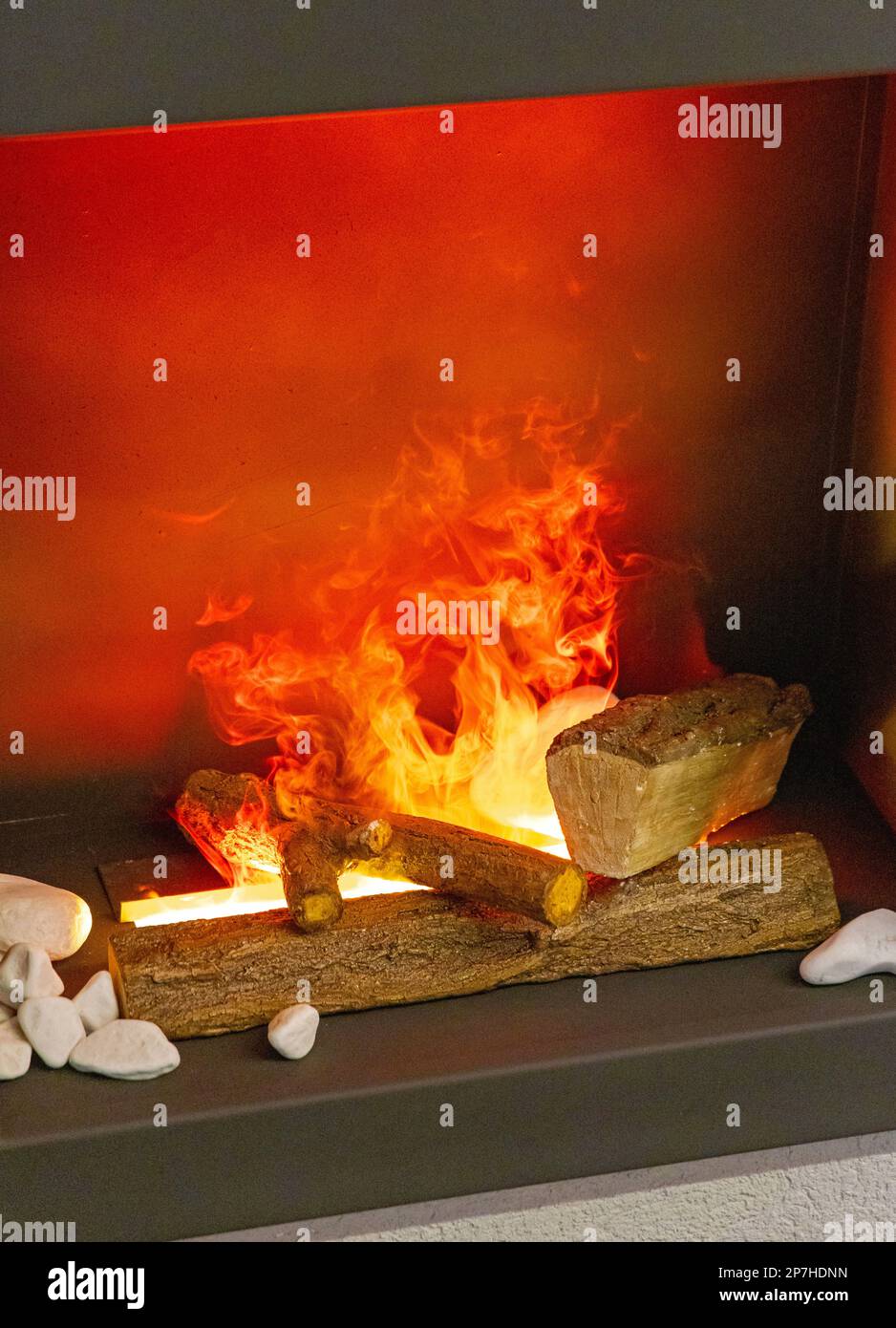 Artificial Ceramic Log Wood Steam Effects in Fireplace Stock Photo