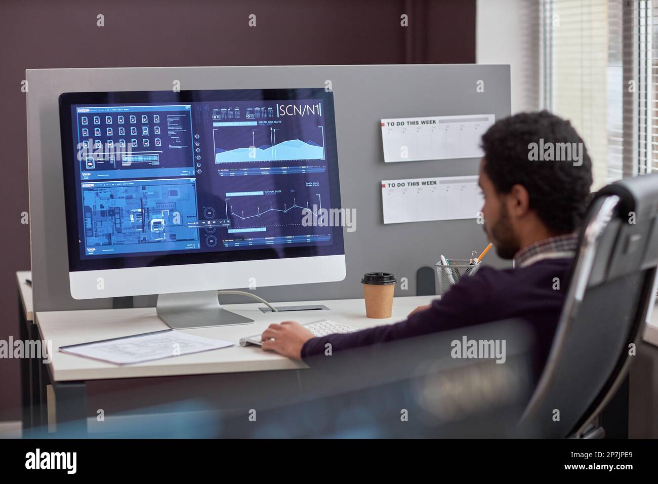 Back view at male IT engineer working with data on computer screen at workplace, copy space Stock Photo