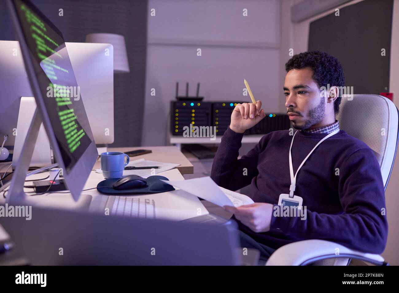 Side view portrait of IT developer working at night writing code and ...