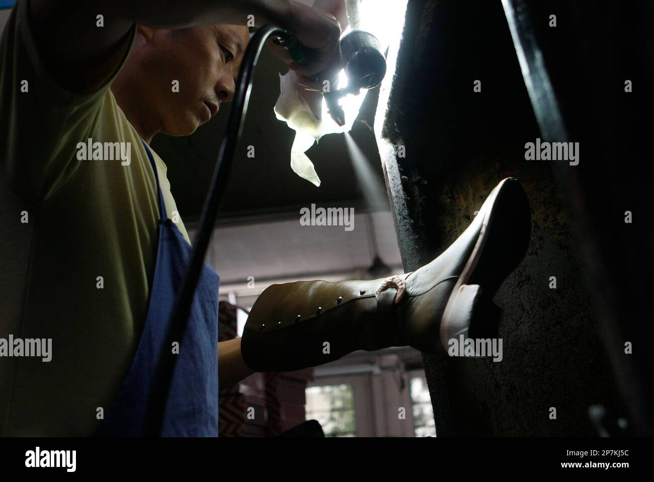 Workers process shoes at the Meilidian shoe factory in Chengdu of