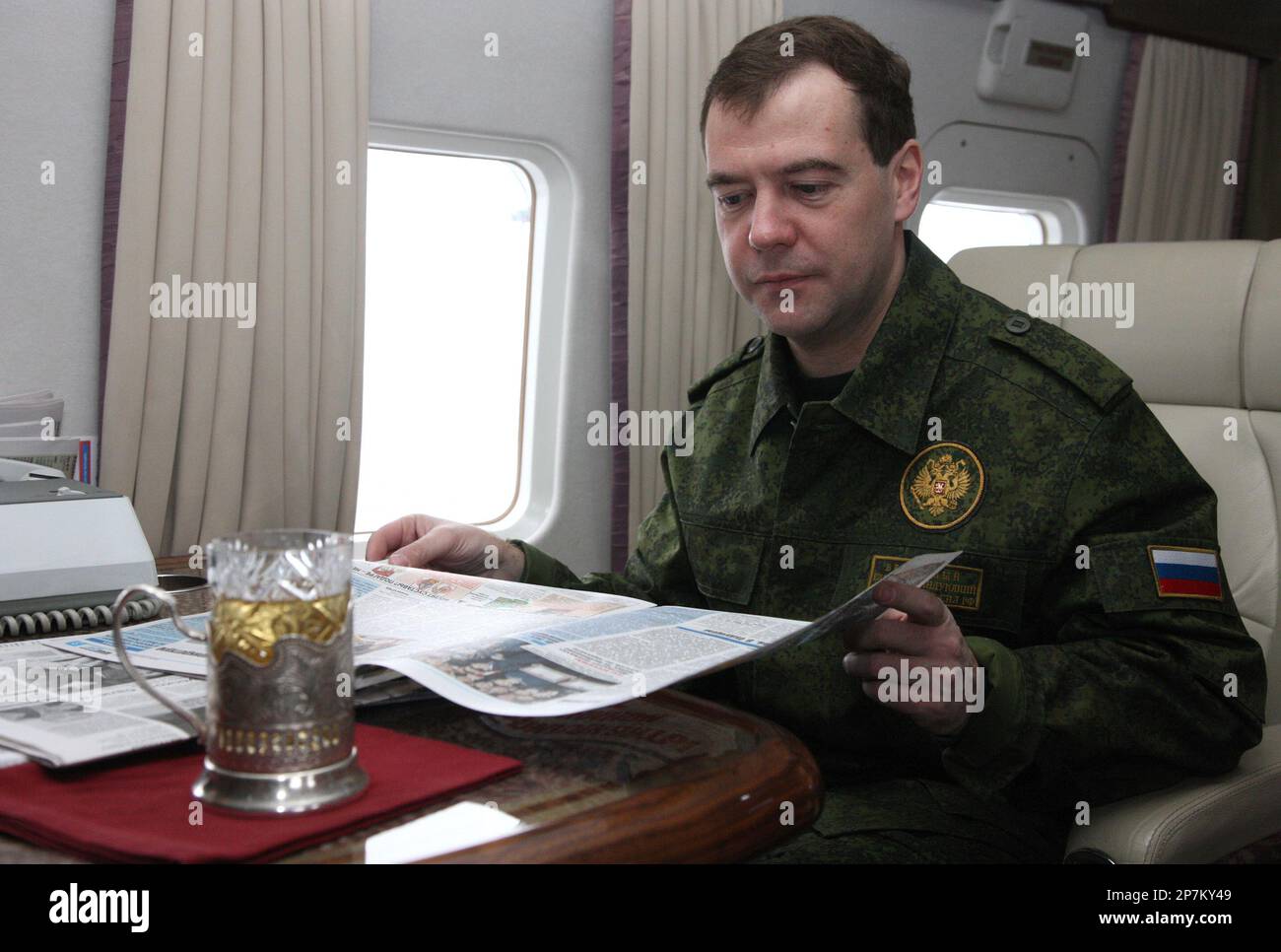 Russian President Dmitry Medvedev reads a newspaper aboard a helicopter ...