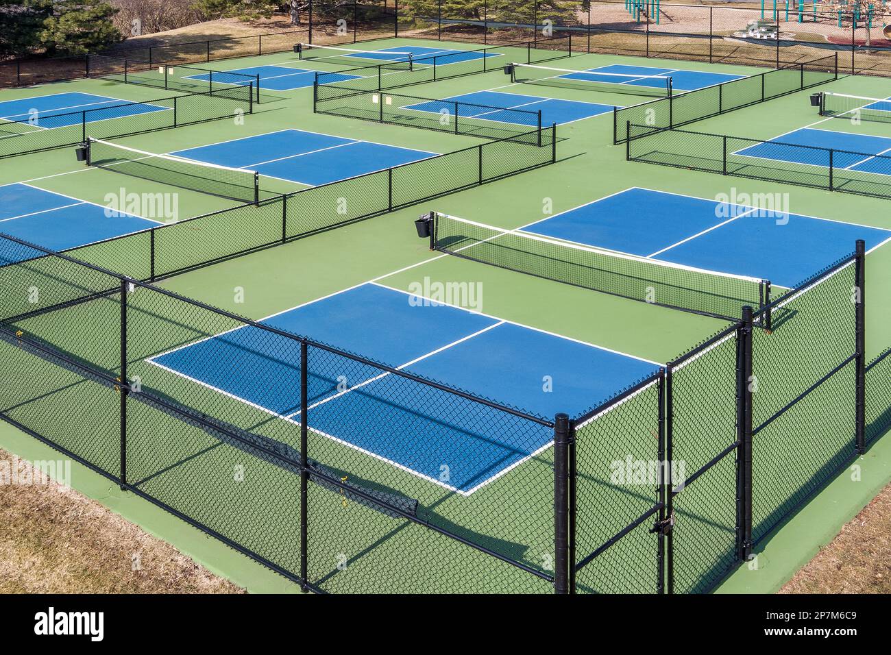 Aerial view of a pickleball complex with blue and green courts beside a