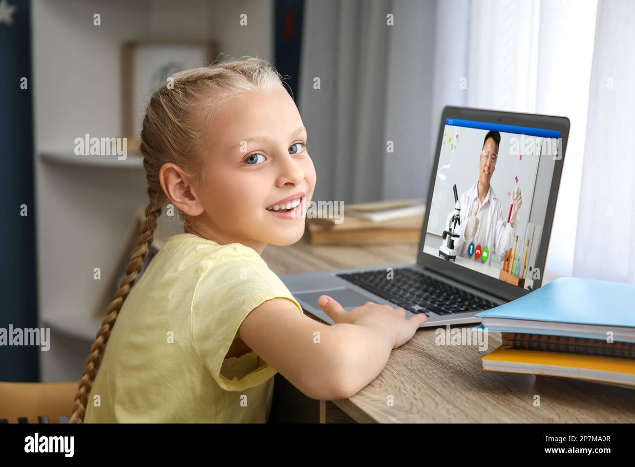 Cute little girl studying online at home Stock Photo - Alamy
