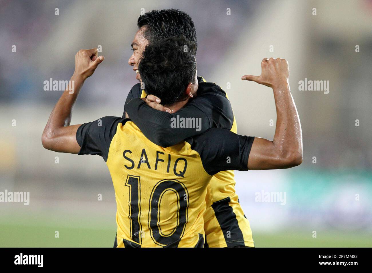Rahim Safiq of Malaysia, celebrates after scoring the third goal, while his  team mate Muslim Mohamad Azmi, right, hugs him on during the semi-final  soccer match between Malaysia and Laos at the