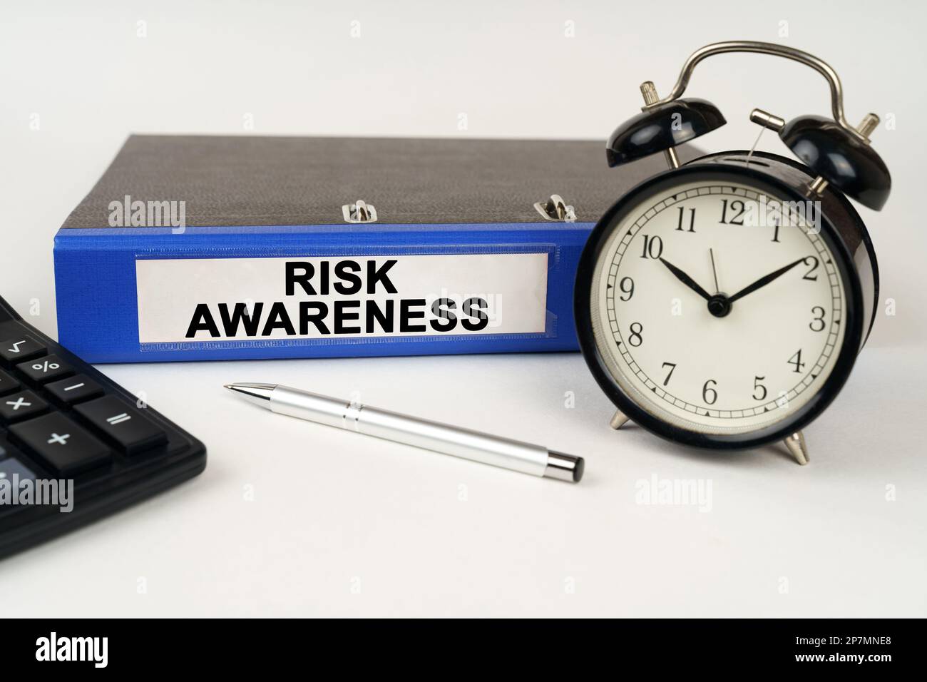 Low Risk Clock Business concept. On a white surface, an alarm clock calculator and a ...