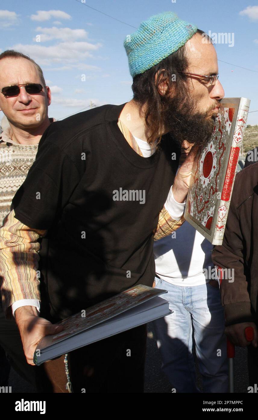 An Israeli Orthodox Jewish man kisses a copy of the Quran, after Jewish