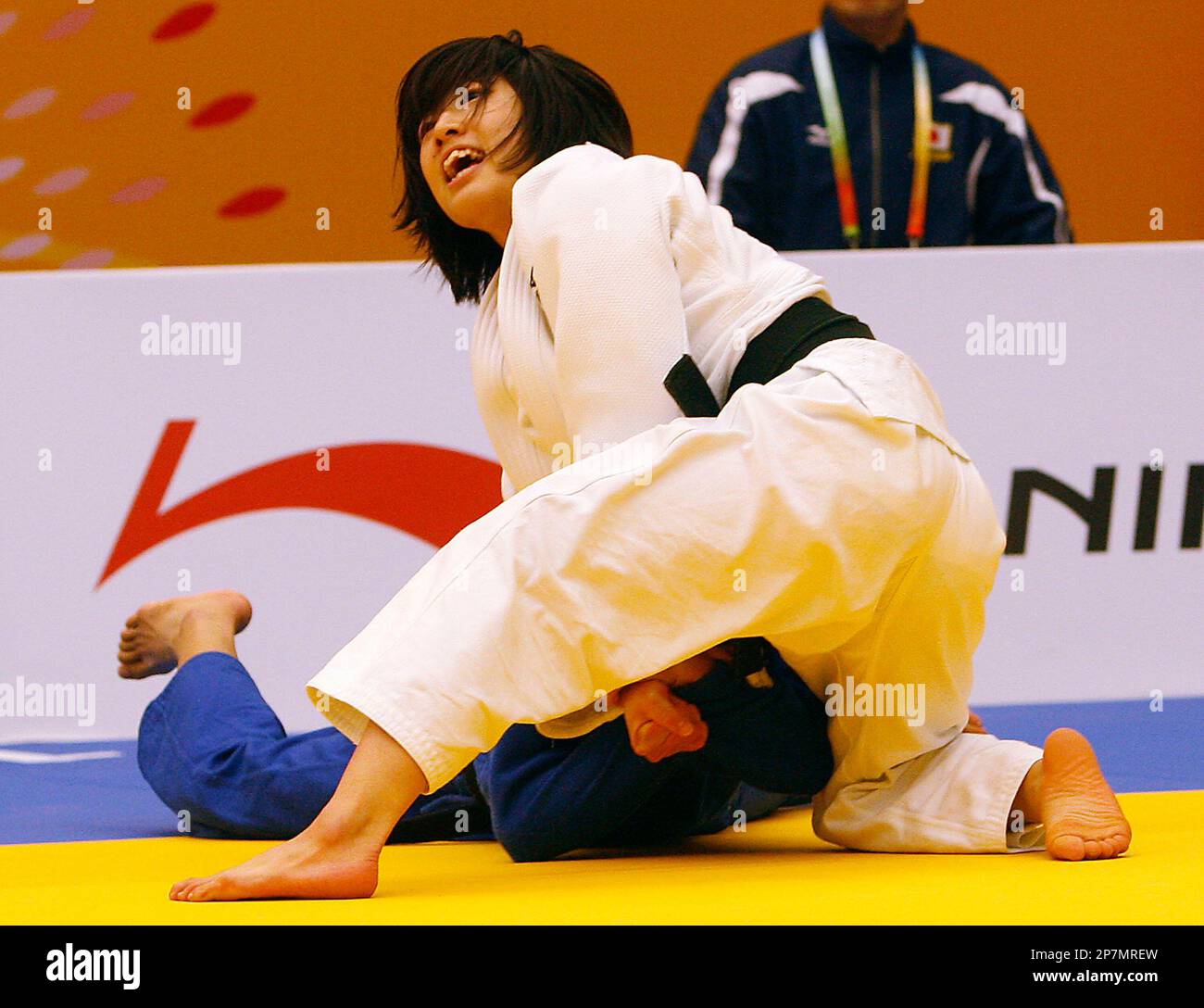 Haruna Asami of Japan, in white uniform, looks at the referee to see her victory against Pak Ok Song of North Korea, in blue uniform, during womens Judo -48-kilogram gold medal finals