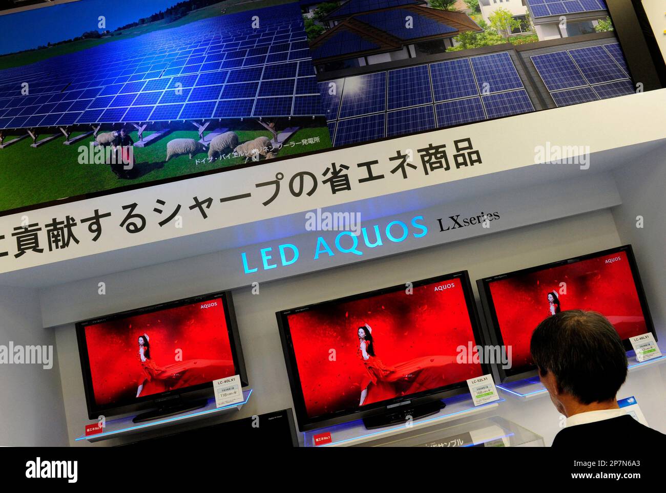 A visitor looks at the LED Aquos liquid crystal display televisions