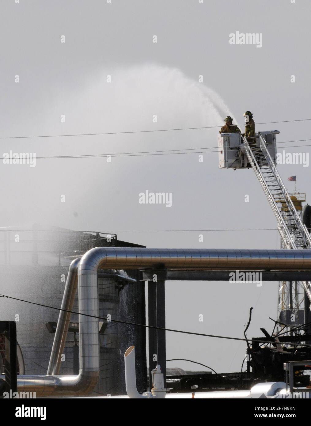 Water is poured on a tank at the American Acryl plant Wednesday, Dec. 9