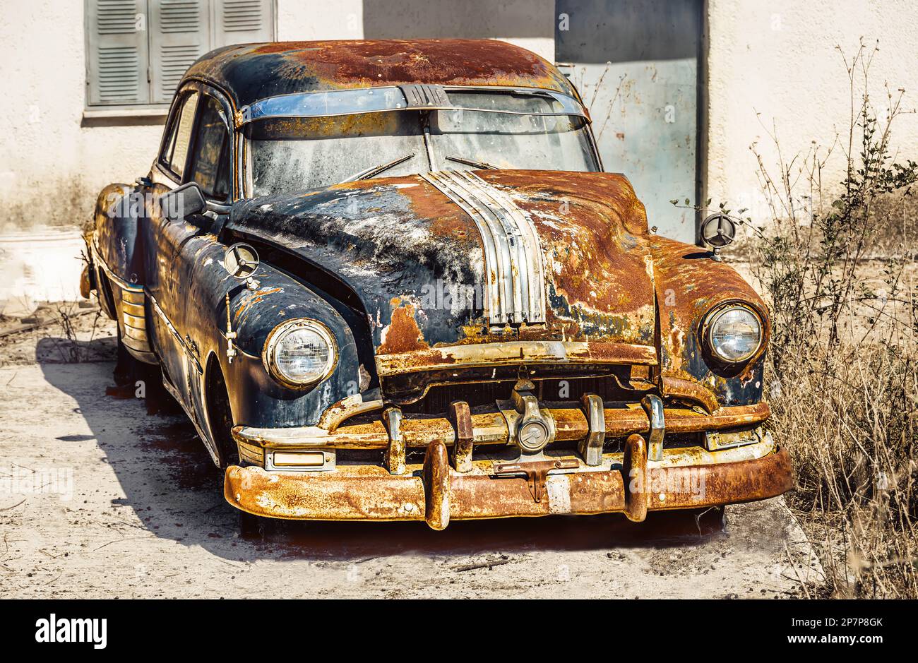 An old classic car, once blue, now covered with rust. It was once a beautiful car, the Pontiac Chieftain Stock Photo