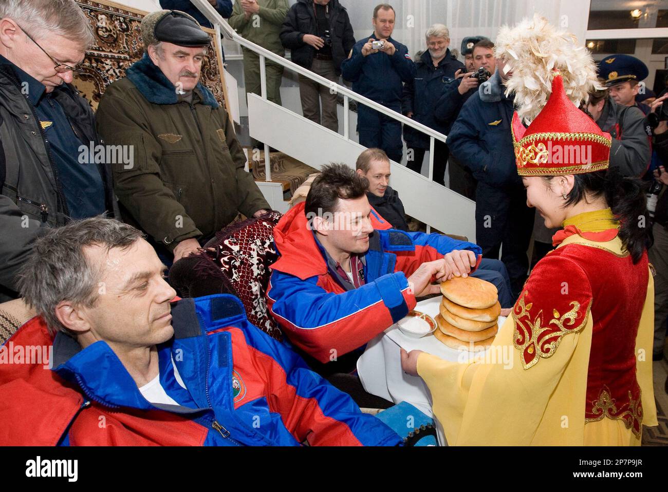 Woman dressed in Kazakh national costume welcomes the International Space  Station crew, European Space Agency astronaut Frank De Winne of Belgium,  right, Russian cosmonaut Roman Romanenko, center, and Canadian astronaut  Robert Thirsk,