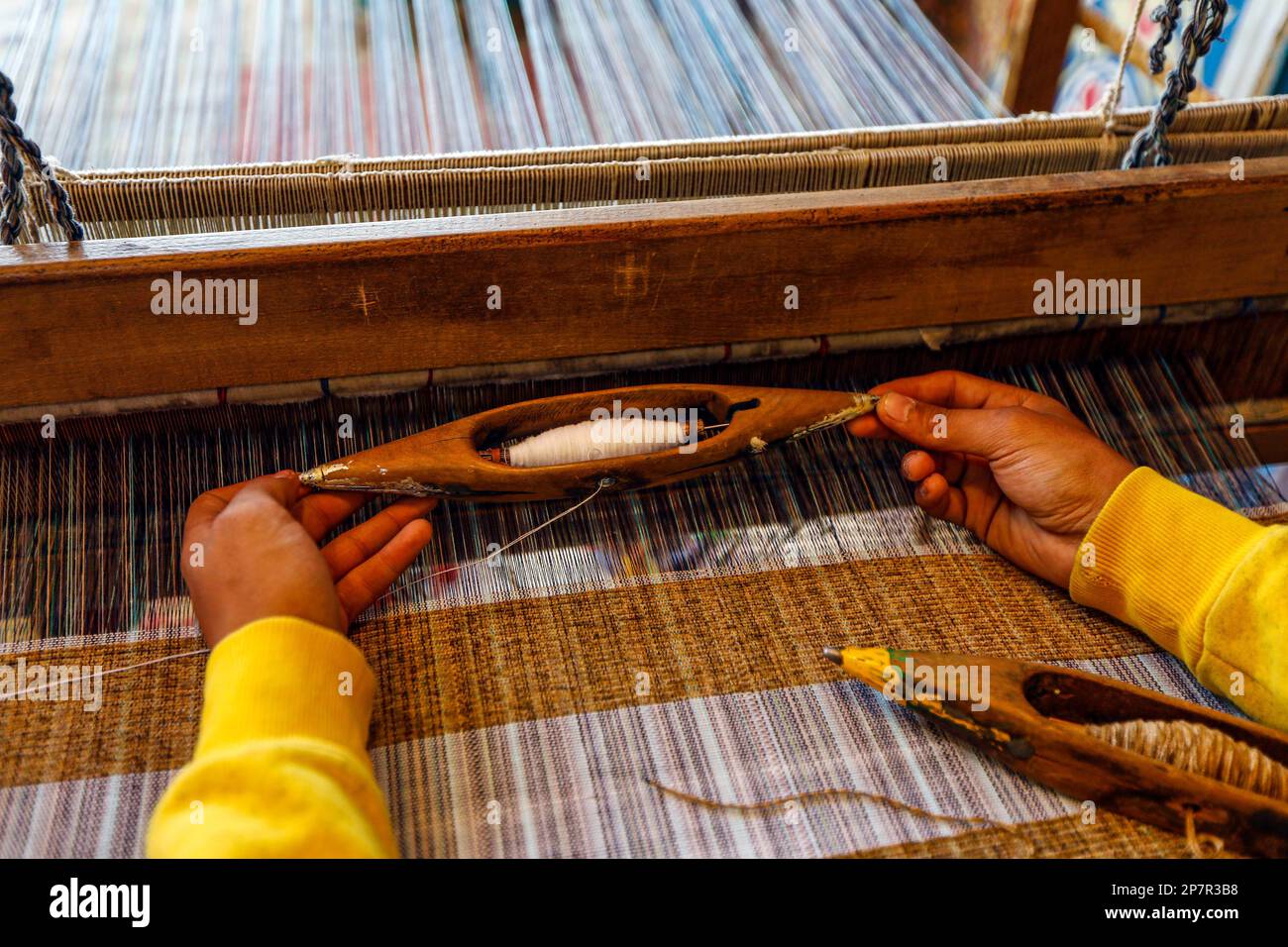 Aswan, Egypt. 8th Mar, 2023. A man prepares to weave with a loom to
