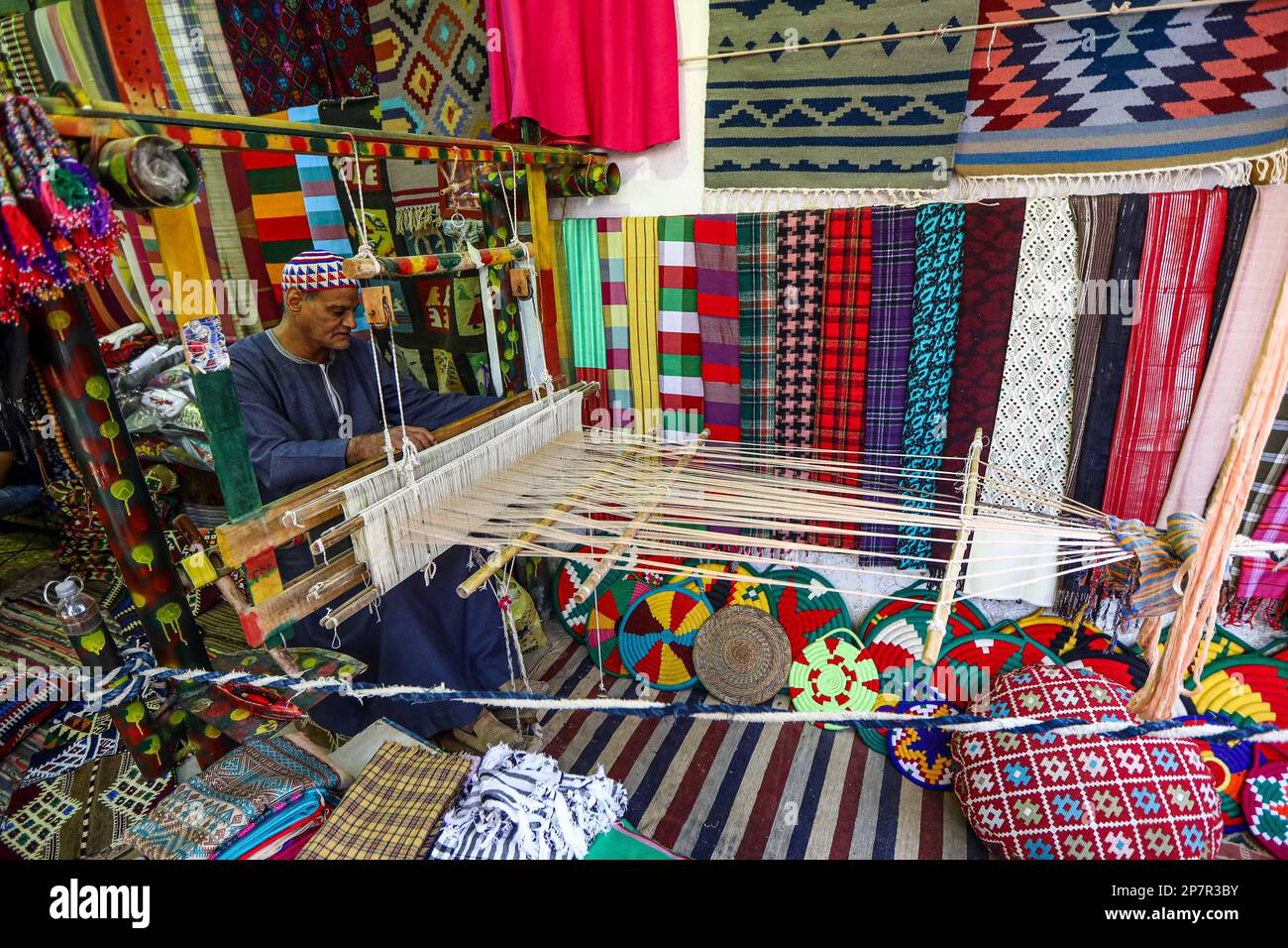 Aswan, Egypt. 8th Mar, 2023. A man weaves with a loom to make
