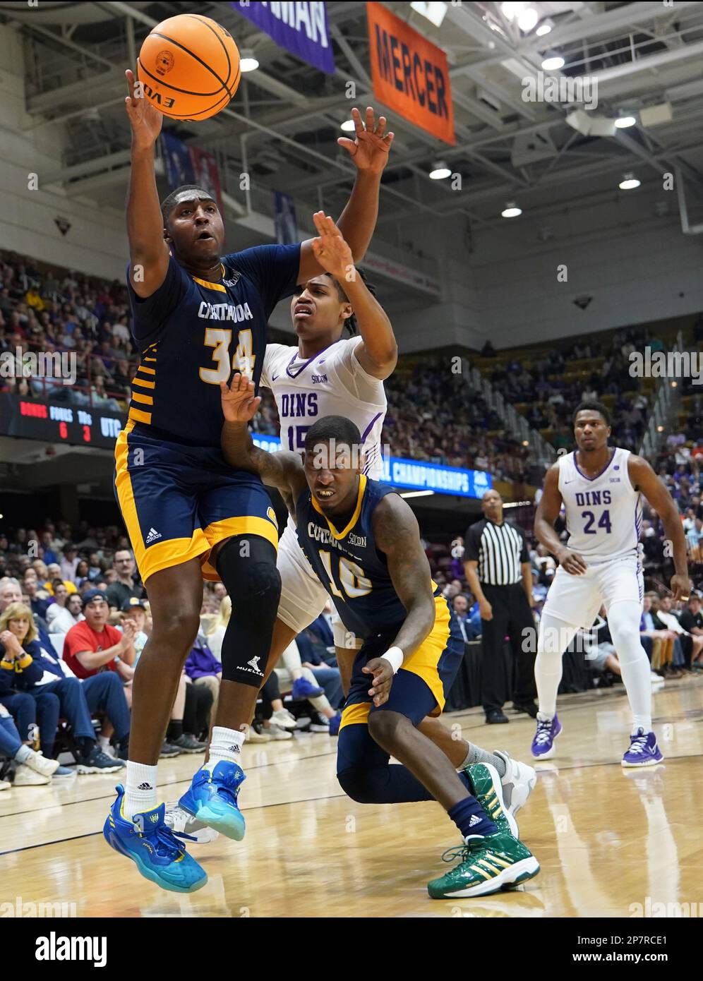 Chattanooga guard Randy Brady (34), Chattanooga guard A.J. Caldwell (0,  left, and Furman forward Jalen Slawson (20) chase down a loose ball during  an NCAA mens college basketball championship game for the