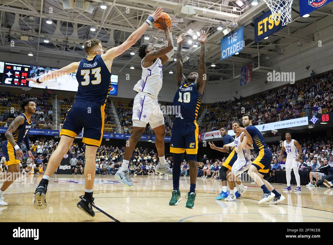 Chattanooga guard Randy Brady (34), Chattanooga guard A.J. Caldwell (0,  left, and Furman forward Jalen Slawson (20) chase down a loose ball during  an NCAA mens college basketball championship game for the