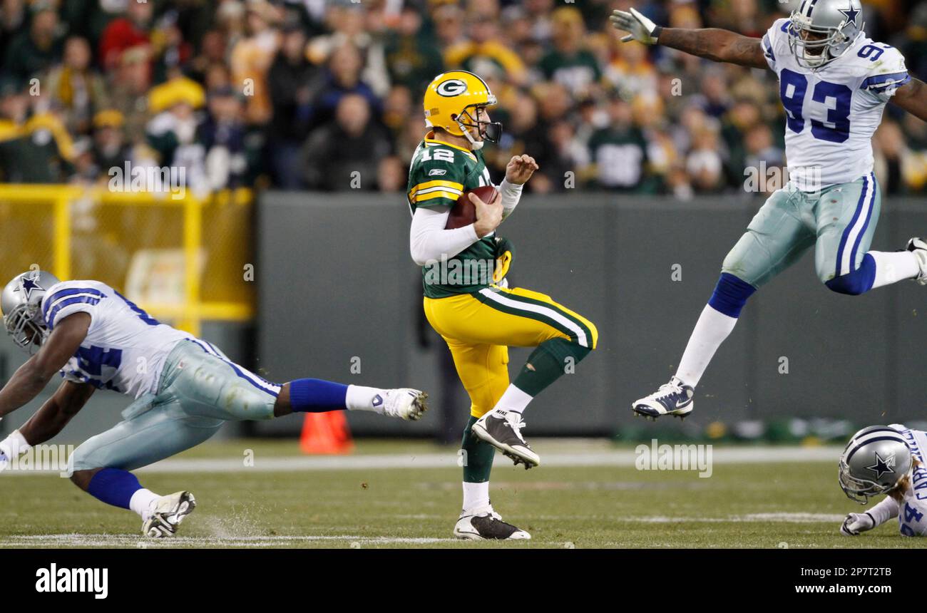 Green Bay Packers quarterback Aaron Rodgers (12) tries to scramble away ...