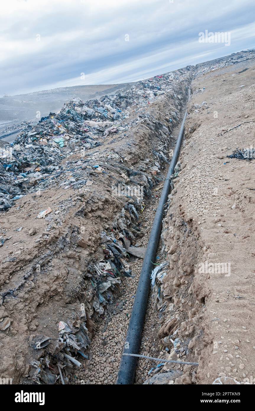 A perforated pipe for methane gas is laid in a trench to be buried in