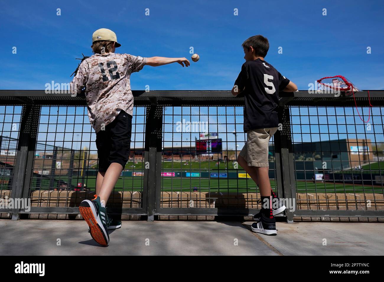Two fans play catch with a member of the Texas Rangers staff before a