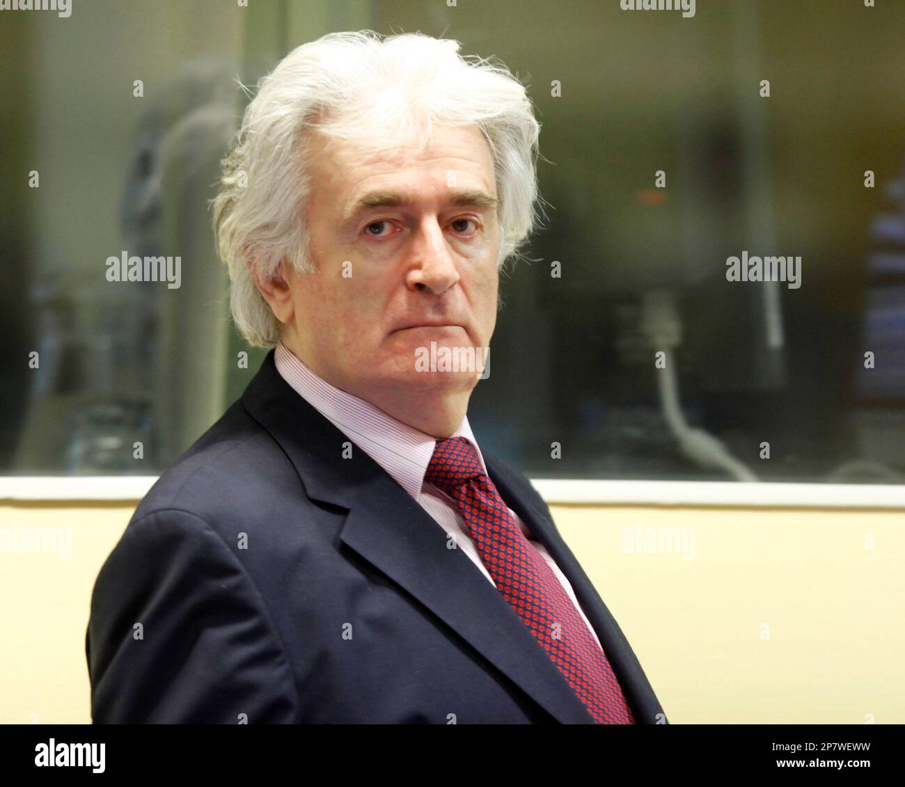 Former Bosnian Serb leader Radovan Karadzic enters the courtroom of the U.N.'s Yugoslav war crimes tribunal in The Hague, Netherlands, Tuesday Nov. 3, 2009. Radovan Karadzic appeared in the courtroom for the first time since his trial began last week on charges of ordering Serb atrocities throughout the Bosnian war. Karadzic has boycotted the trial's first three days, saying he has not had enough time to prepare his defense even though he was indicted in 1995. (AP Photo/Michael Kooren/Pool) Stock Photo
