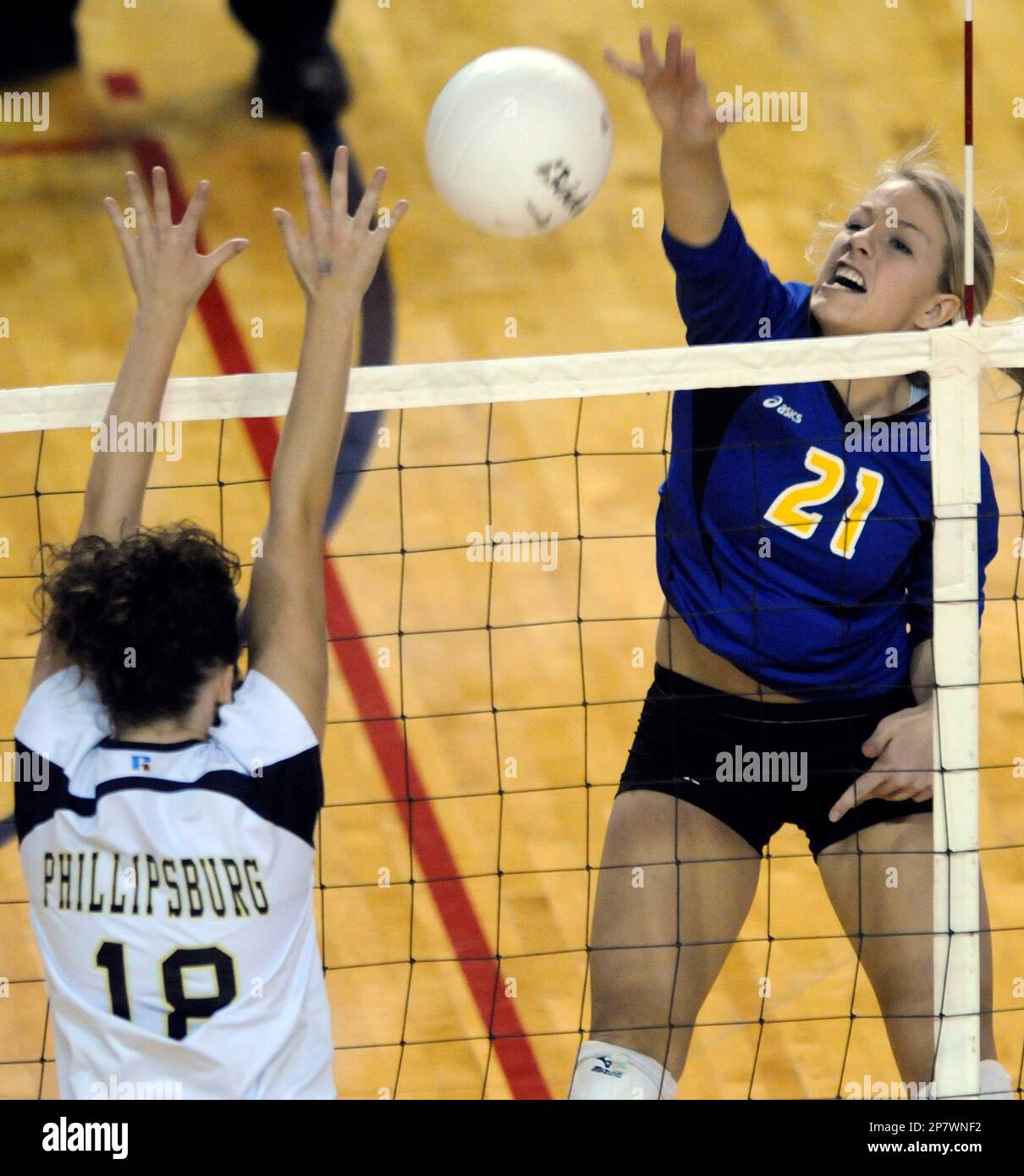 Feist of Wichita Collegiate spikes the volleyball over Haley