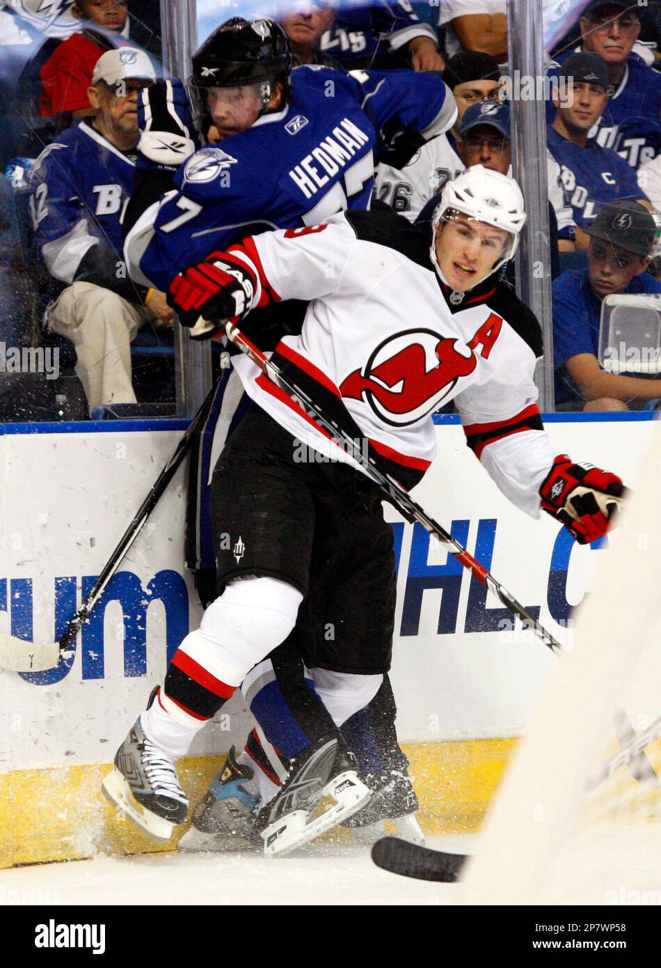New Jersey Devils' Zach Parise checks Tampa Bay Lightning's Victor Hedman, of Sweden, into the