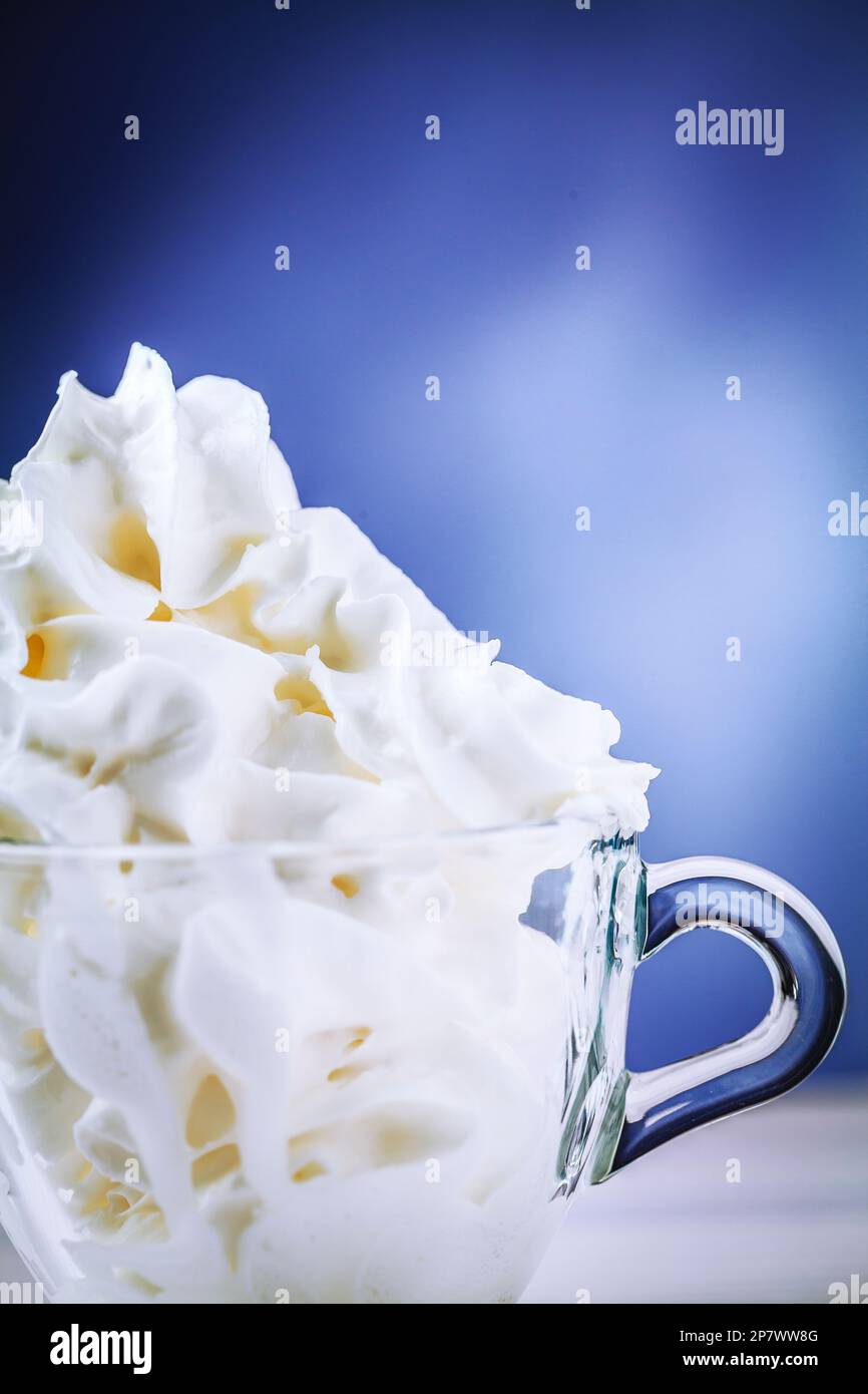 Sweet whipped cream for dessert in a small glass cup to taste Stock