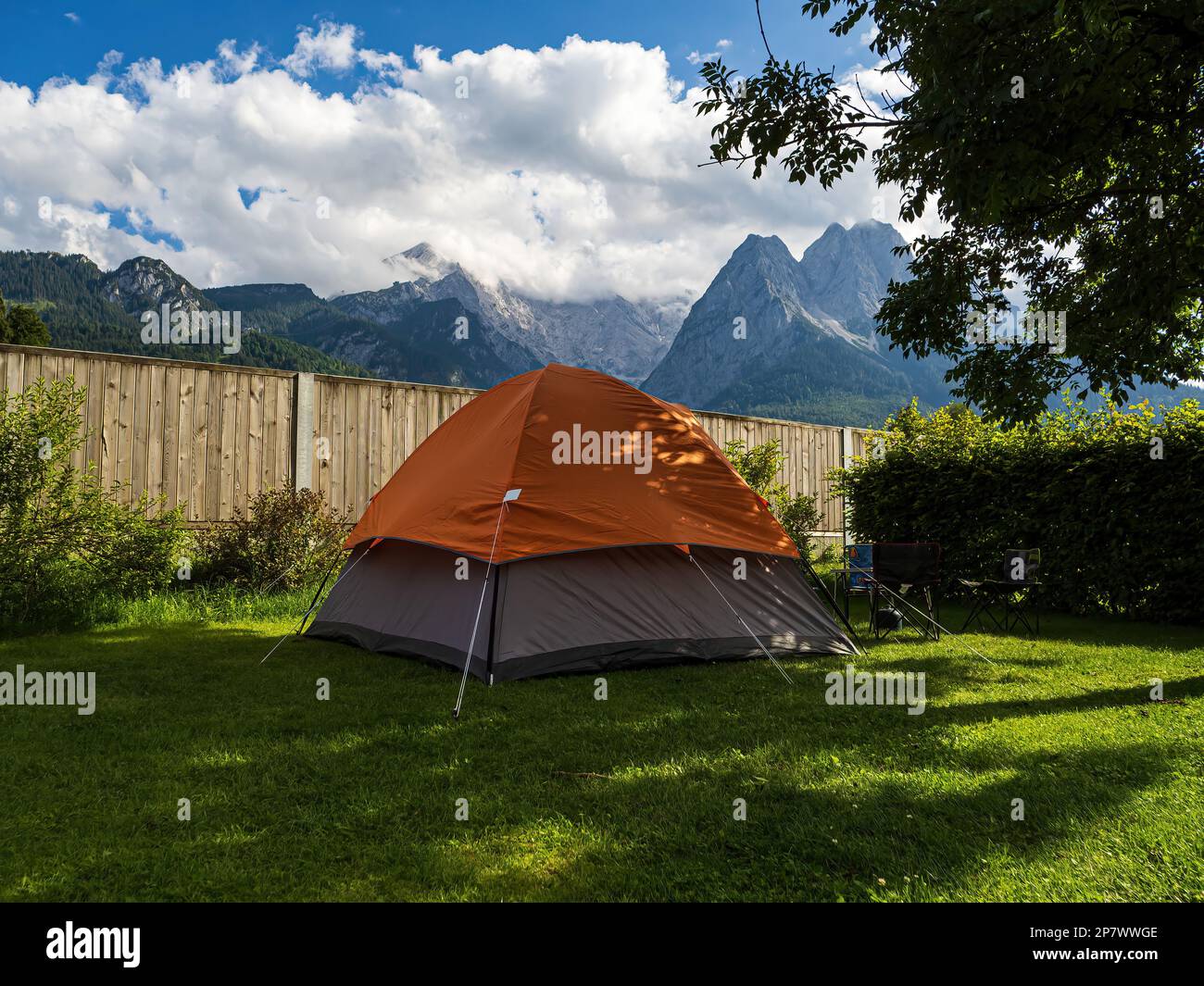 Camping with an orange tent at the foot of Zugspitze, Bavaria, Germany