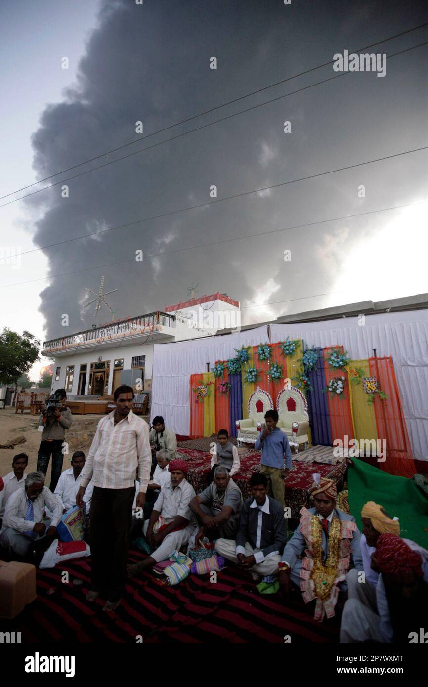 A groom, wearing garland made of currency notes, sits at a wedding