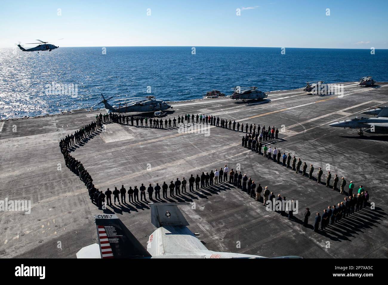 230307-N-MZ309-1046 ADRIATIC SEA (March 7, 2023) Sailors assigned to the George H.W. Bush Carrier Strike Group (CSG) pose for a photo in the shape of Texas on the flight deck of the Nimitz-class aircraft carrier USS George H.W. Bush (CVN 77), March 7, 2023. The George H.W. Bush CSG is on a scheduled deployment in the U.S. Naval Forces Europe area of operations, employed by U.S. Sixth Fleet to defend U.S., allied, and partner interests. (U.S. Navy photo by Mass Communication Specialist 1st Class Ryan Riley) Stock Photo