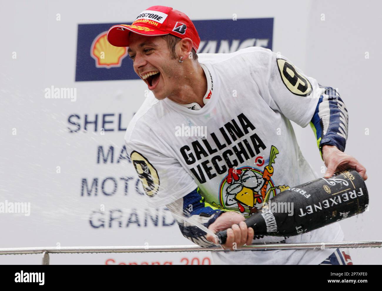 Italy's Valentino Rossi sprays champagne as he after winning the MotoGP World Championship with his third place finish at the Malaysian Grand Prix motorcycle racing at the Sepang International