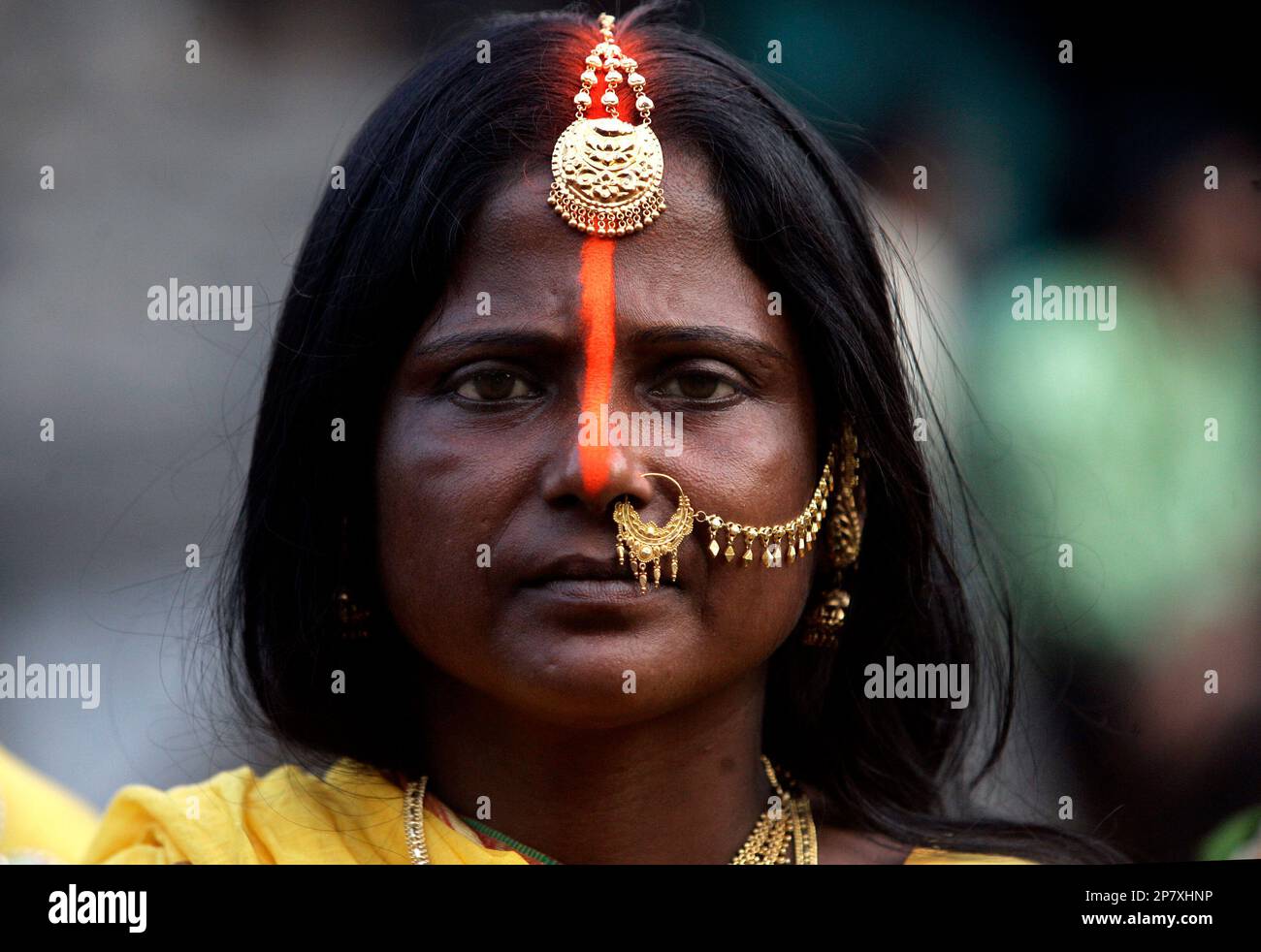 A Hindu woman looks on as she performs rituals on the banks of the