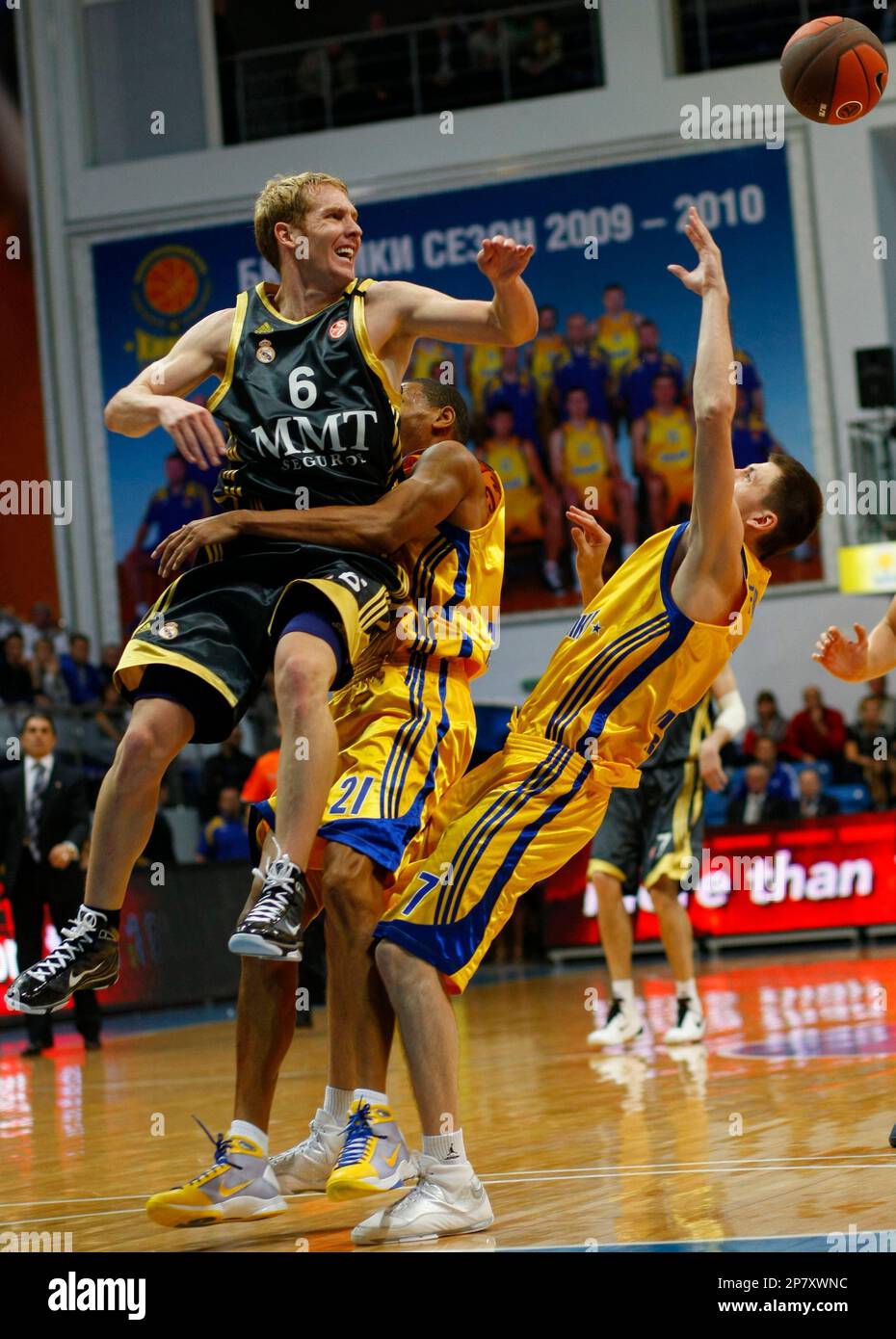 Real Madrid's Travis Hansen, top, drives to the basket as BC Khimki's Kelly  McCarty, behind, and Vitaly Fridzon, right, block him during their  Euroleague match group D in Moscow, Russia, Thursday, Oct.