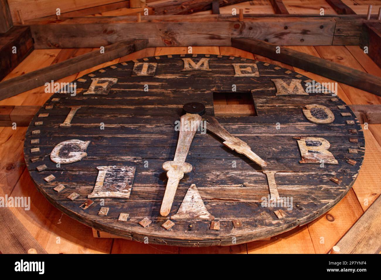 A weathered handmade wooden clock face hangs on a barn ball at the Tuck