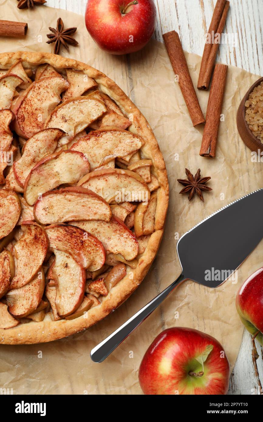 Delicious apple pie and ingredients on white wooden table, flat lay Stock Photo