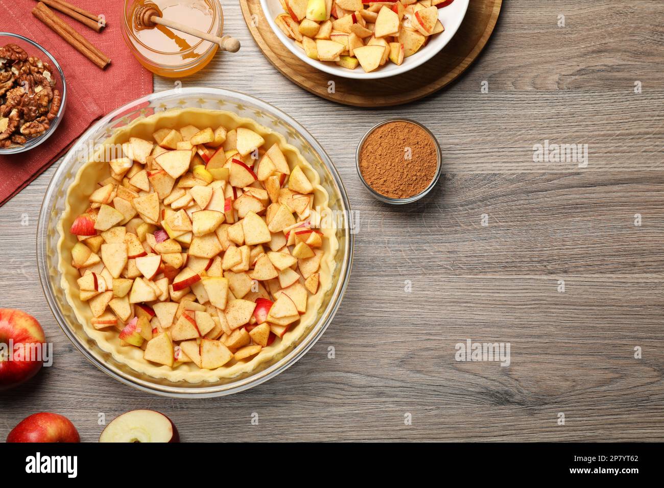 Flat lay composition with raw dough and ingredients for apple pie on wooden table Stock Photo