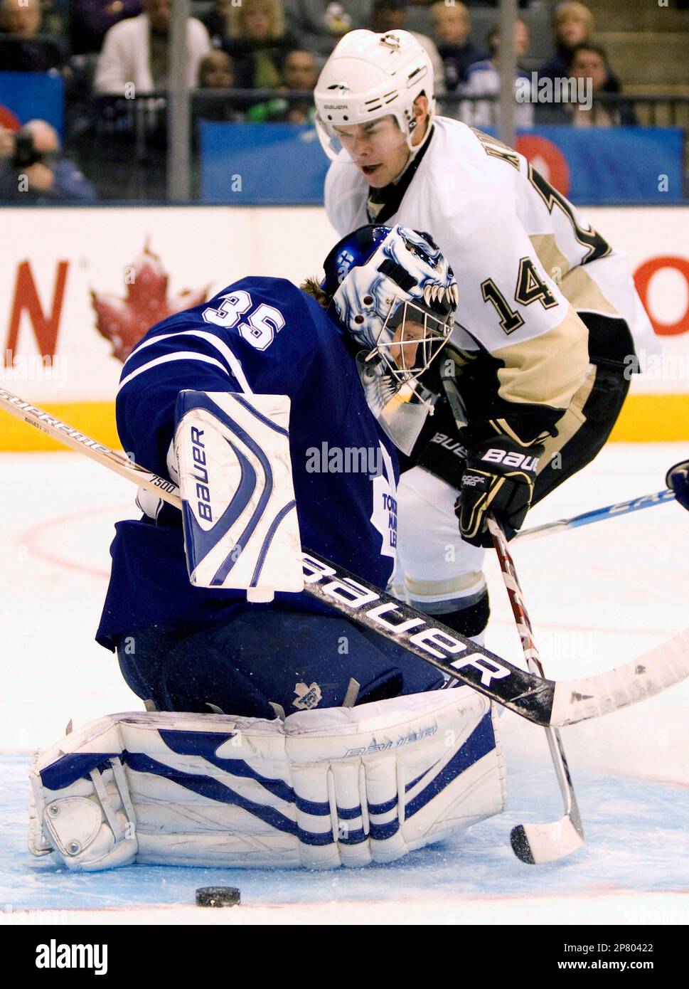 Pittsburgh Penguins left winger Chris Kunitz (14) tries to feed the puck  around Toronto Maple Leafs goaltender Vesa Toskala, of Finland, during  third-period NHL hockey game action in Toronto on Saturday, Oct.