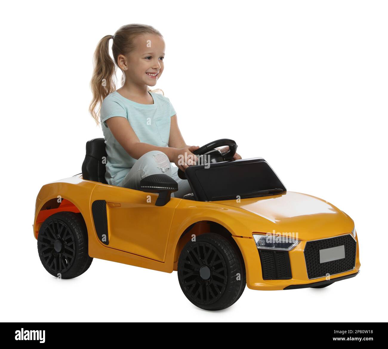 Cute little girl driving children's electric toy car on white