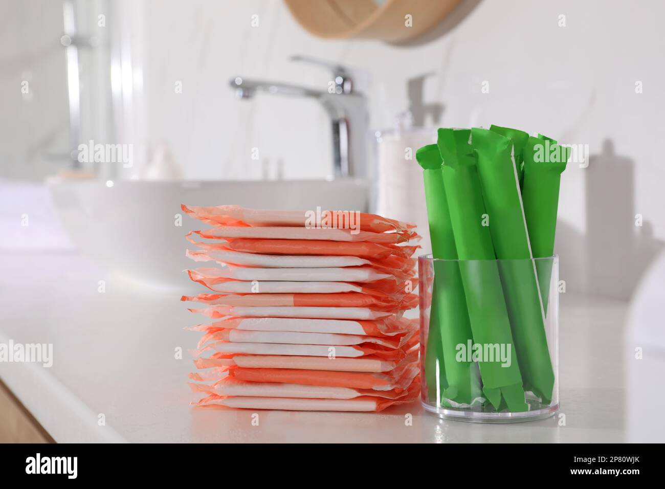 Tampons and menstrual pads on counter in bathroom. Feminine hygiene