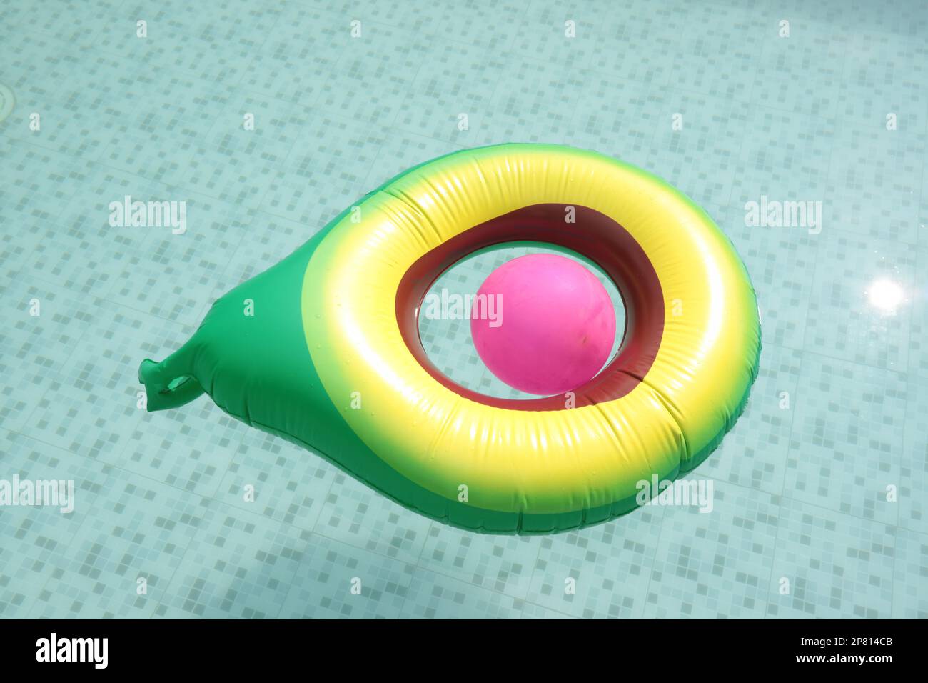 yellow green pool float, floating in the refreshing blue swimming pool Stock Photo
