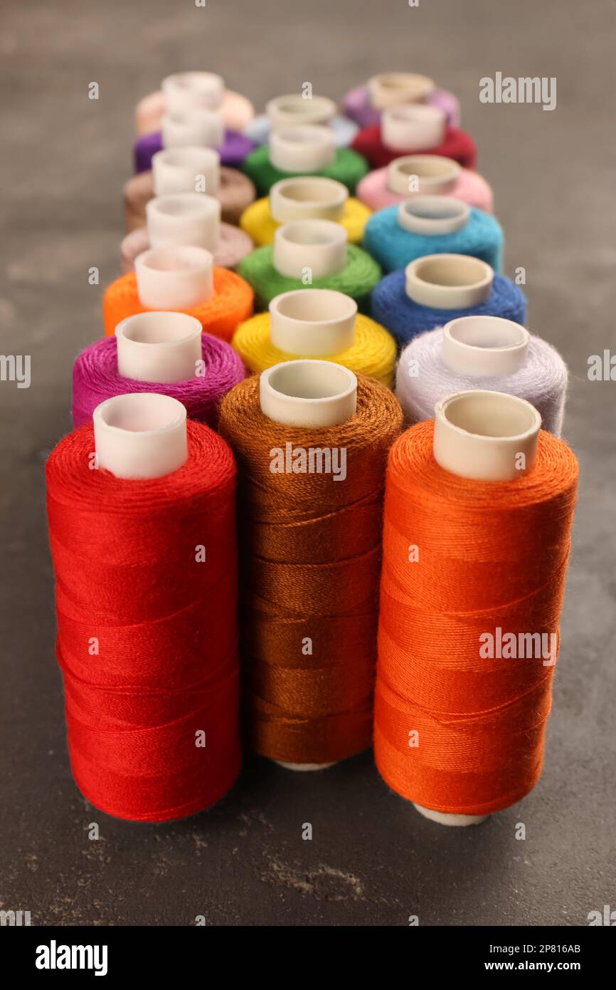 Set of color sewing threads on grey table Stock Photo