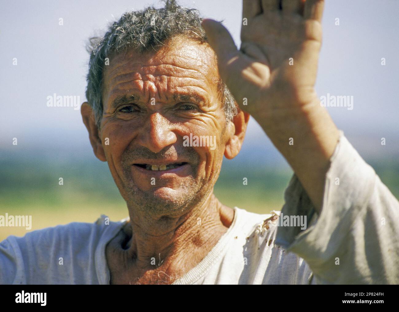 A middle-aged peasant farmer in southwestern Bulgaria waves to passers-by Stock Photo