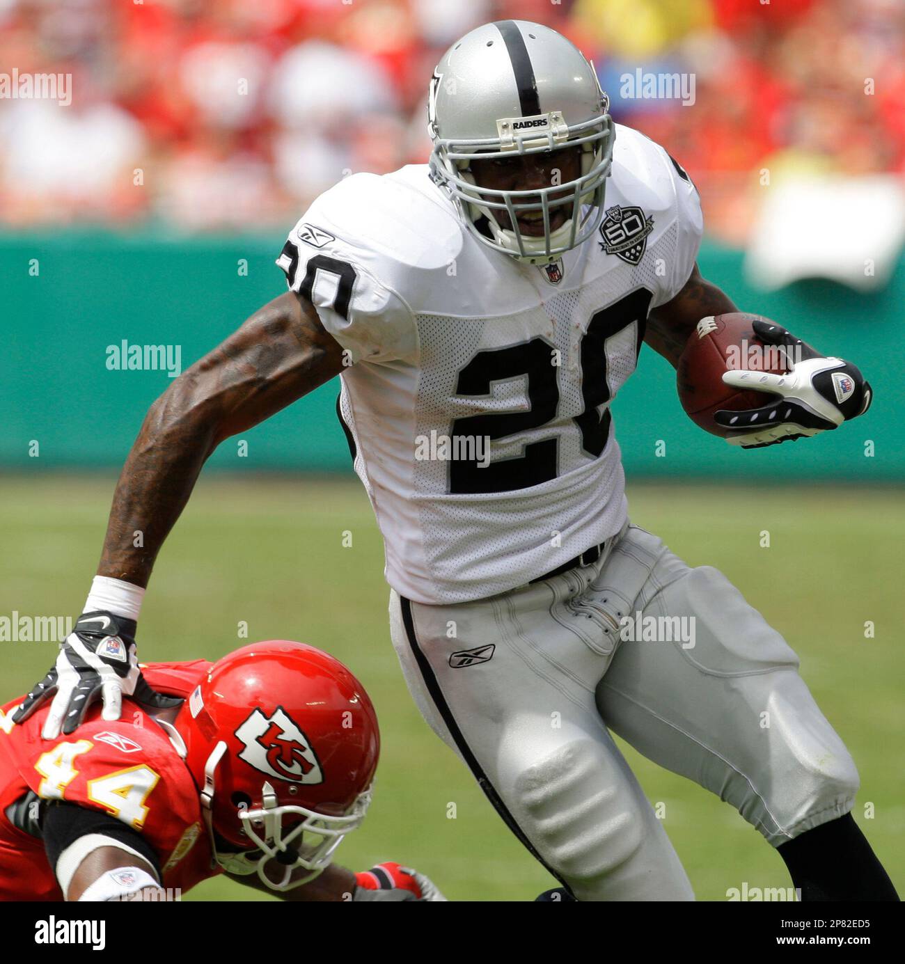 Oakland Raiders running back Darren McFadden (20) pushes off of Kansas City  Chiefs safety Jarrad Page (44) during the first half of an NFL football  game Sunday, Sept. 20, 2009, in Kansas