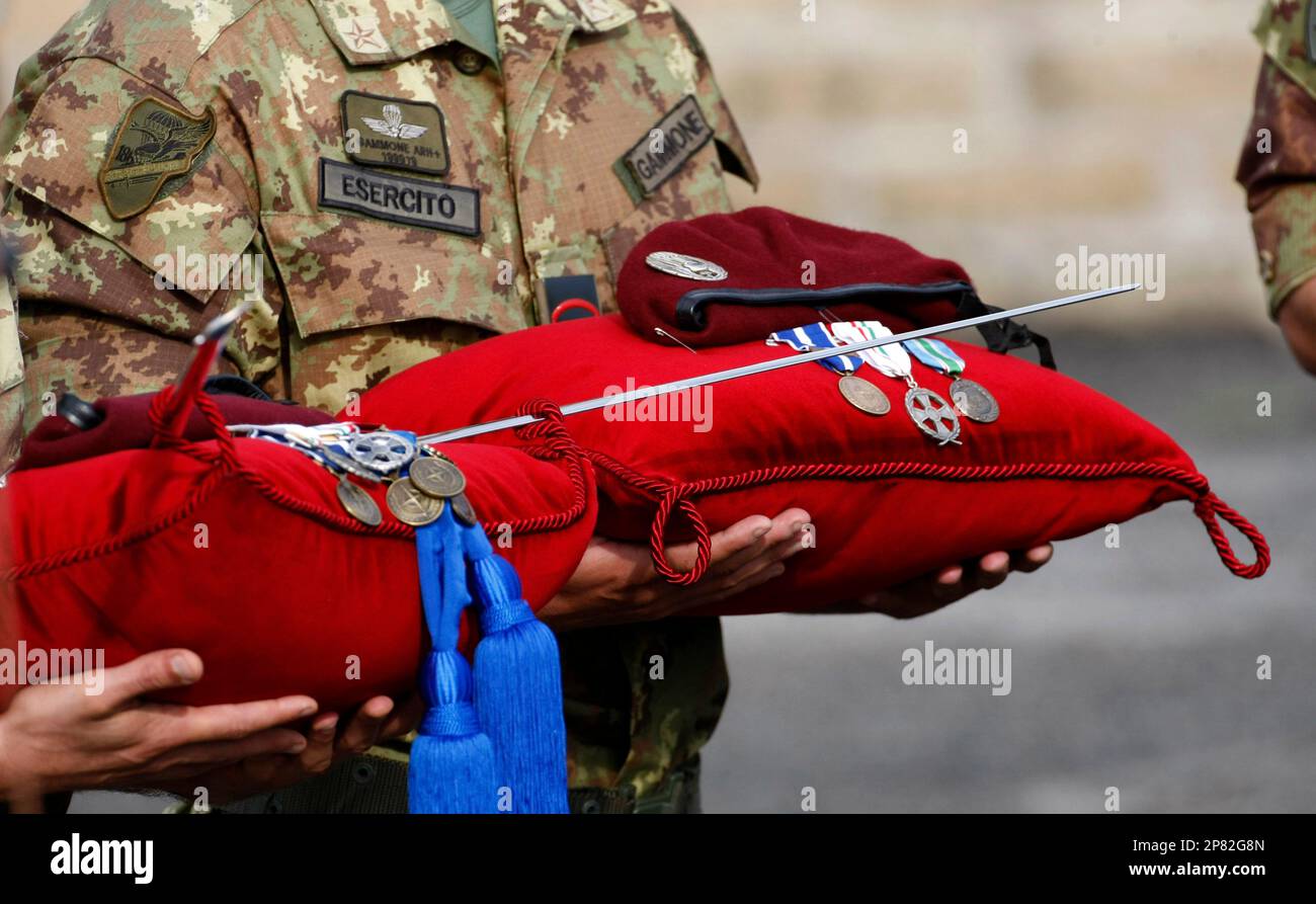 Two soldiers hold the medals and sword of two of the six soldiers who died in an attack to an Italian military convoy in Kabul on Thursday Sept. 17 upon the arrival of the coffins of the victims at Ciampino military airport, near Rome, Sunday, Sept. 20, 2009. The victims, all paratroopers of the Italian 186th Folgore regiment, were, 1st Corporal Major Matteo Mureddu; 1st Corporal Major Davide Ricchiuto; Liutenant Antonio Fortunato; Sargeant Major Roberto Valente; 1st Corporal Major Giandomenico Pistonami; Corporal Major Massimiliano Randino. (AP Photo/Pier Paolo Cito) Stock Photo