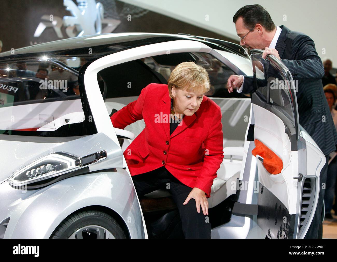 Jean-Marc Gales, Director General of Peugeot, right, and German Chancellor  Angela Merkel test a Peugeot Concept Car during the opening of the  Frankfurt Auto Show in Frankfurt, Germany, Thursday, Sept. 17, 2009.