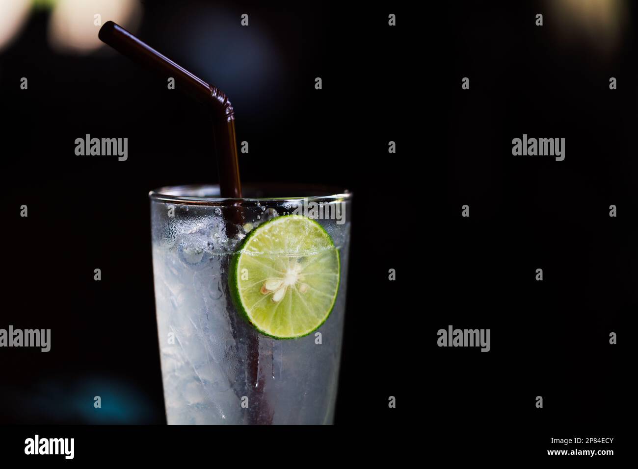 Healthy drinks, close up a glass of fresh lime soda with dark background, iced drinks fresh lime soda in cleared long glass, a piece of sliced lime, e Stock Photo