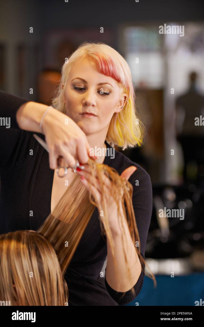 Maintaining her style. a female hairdresser cutting a clients hair