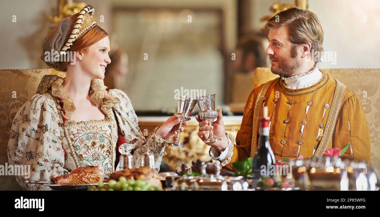 Heres to a long rule my queen. a noble couple toasting while eating
