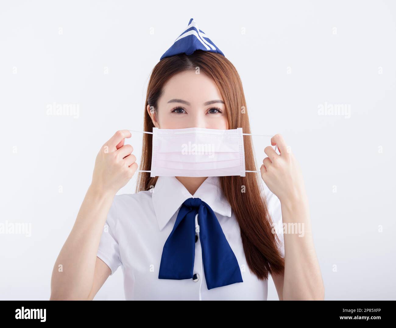 Young woman air hostess in  uniform with white mask Stock Photo