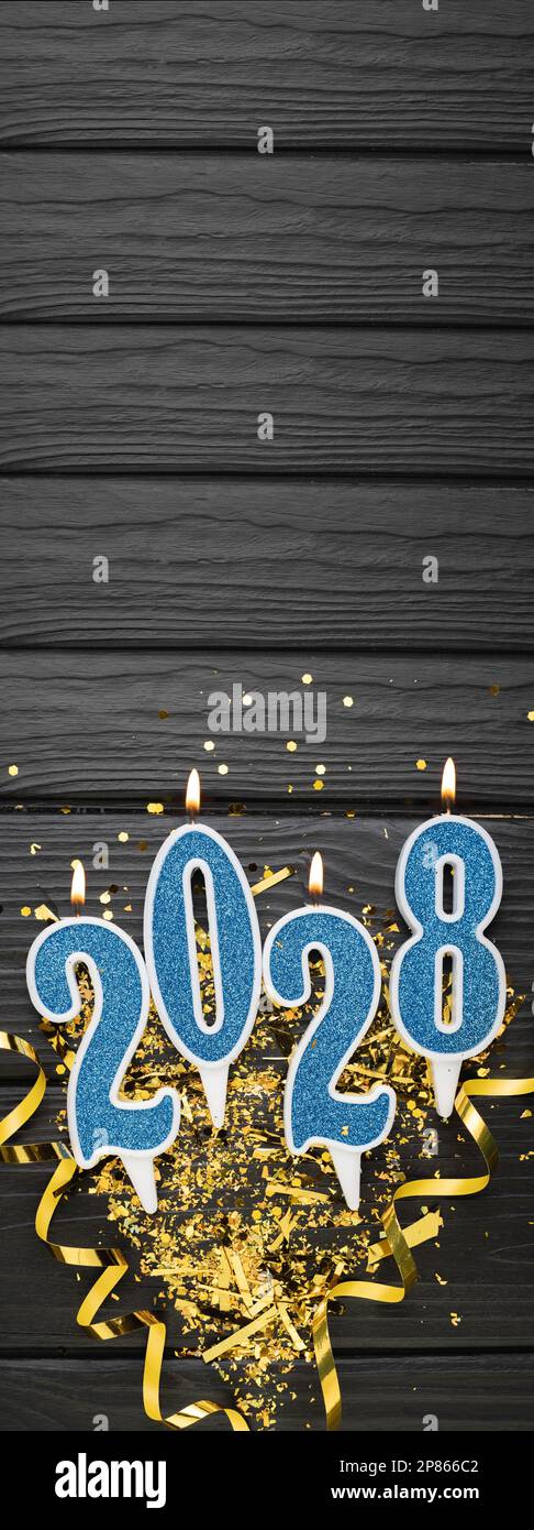 New year 2028 celebration greeting card background blue numbers 2028 with golden party decoration, confetti on dark wooden background. Flat lay, Merry Stock Photo