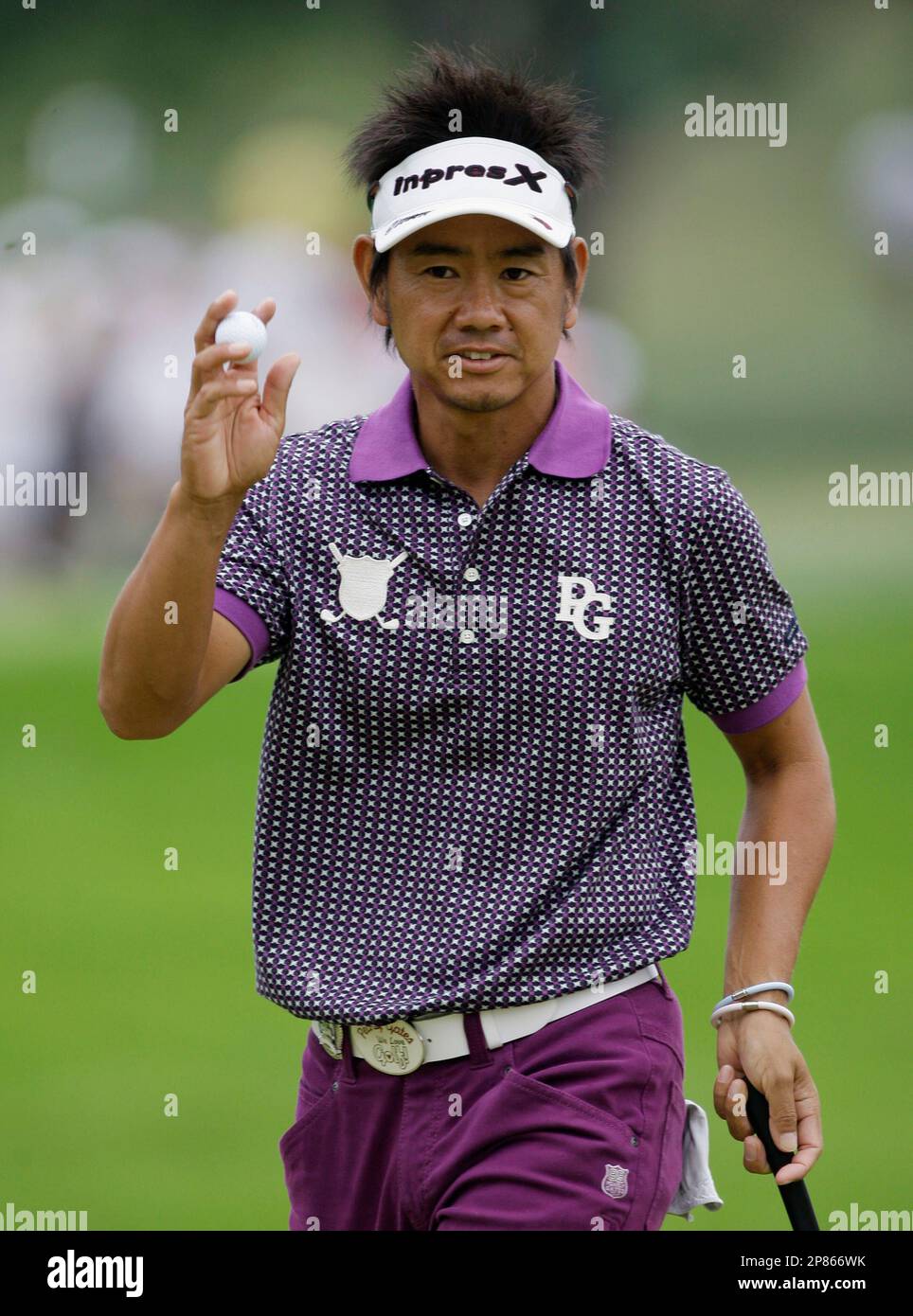 Hiroyuki Fujita, of Japan, holds up his ball after his birdie on